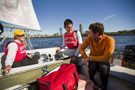 9/24/13 -- Boston, MA Stan Schreyer, coaches Sailing Club team members Maggie Swanson (ENG'17), left, and Connor Astwood (CAS'17) September 24, 2013 during practice on the Charles River. Photo by Cydney Scott for Boston University Photography