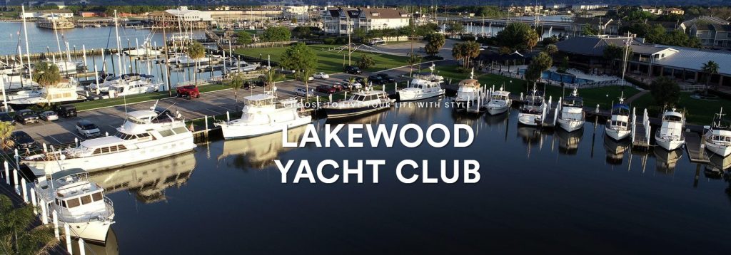 Aerial view of Lakewood Yacht Club with several docked yachts, surrounding buildings, and green lawns on a sunny day. 'LAKEWOOD YACHT CLUB' text is overlaid on the image.
