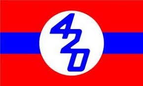 A red flag with a horizontal blue stripe and a white circle in the center. Inside the circle, the number 